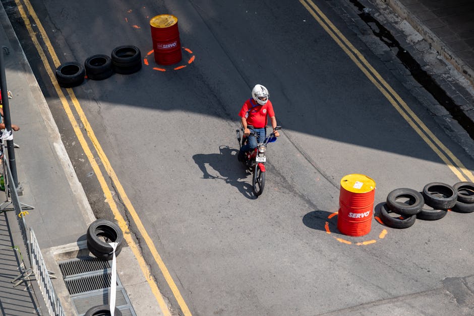 Motorcyclist navigating a strategic urban training course with cones and barriers.