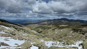 Stunning view of the rocky landscape and distant mountains under dramatic clouds in Castile and León, Spain.